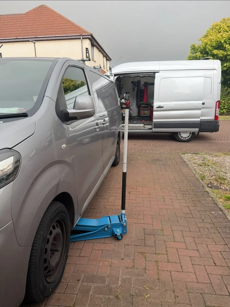 A mobile tyre fitting van and equipment van parked on a driveway