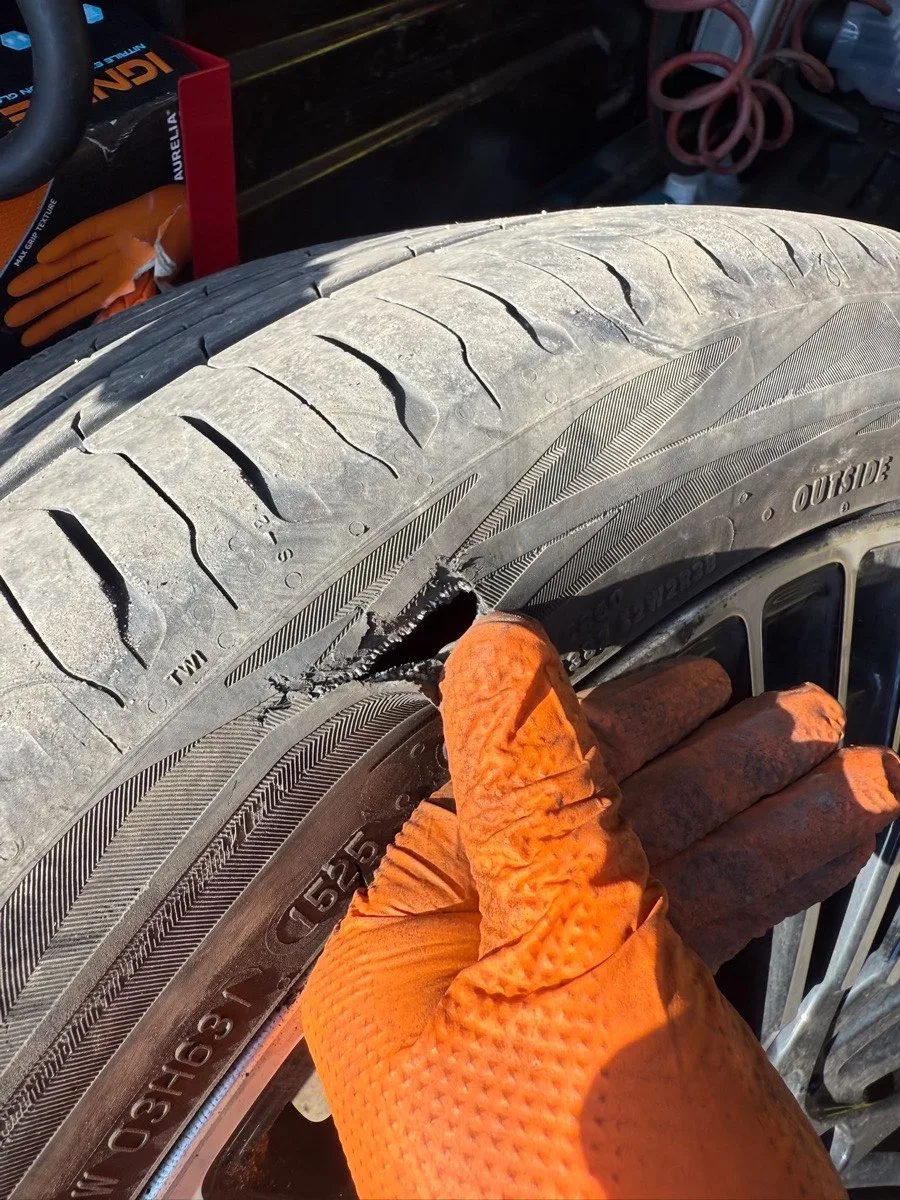 Mobile tyre fitting work beside a vehicle